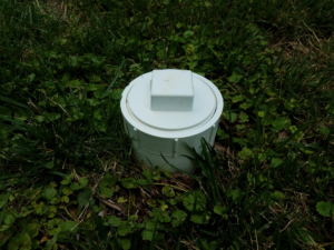 Close up of sewer cleanout in homeowner's yard